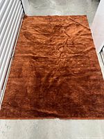 Full view of rust brown plush area rug laid flat