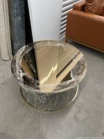 Top view of round coffee table with mirrored surface and plastic wrap
