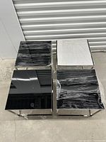 Four small cube side tables showing black and film-covered tops