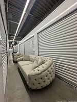 Sofa in storage unit showing full length, tufting, chrome legs