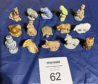 Group shot of all fourteen Wade porcelain figurines on blue cloth
