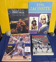 Front covers of two calendars and two Tuff Stuff magazines displayed upright