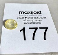 Oval yellow sapphire on MaxSold lot card showing size and color