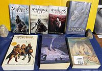 Seven pictured fantasy books arranged upright and flat