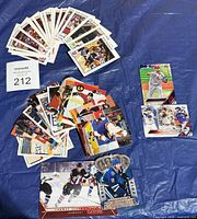 Overall view of all sports cards laid out on blue surface with lot tag