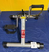 Side view of InStride folding pedal exerciser showing frame, pedals, tension knob