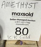 Overall view of 10K gold ring with amethyst next to lot card