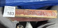 Spine view of red cloth hardcover 'The Wandering Jew' showing worn gilt title