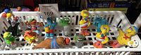 All twelve Sesame Street PVC figurines arranged in plastic basket