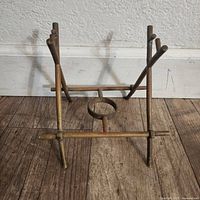 Front view of bronze teapot warming stand showing cross-bar structure and burner ring