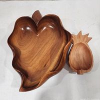 Top view of both wooden bowls, showing leaf and pineapple shapes.