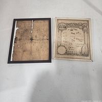 Two framed documents side by side showing overall condition