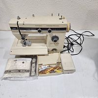 Full view of sewing machine with accessories arranged in front, showing overall lot contents