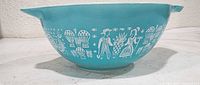 Side view showing full Amish Butterprint design on turquoise bowl