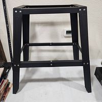 Front view of black steel sawhorse base showing full structure