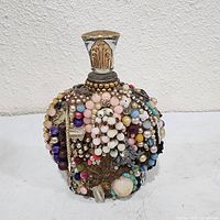 Front view of beaded memory bottle showing stopper and bead arrangement