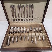 Open case displaying knives, forks, spoons in slots
