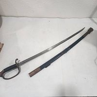 Sword unsheathed beside scabbard showing full length and blade etching