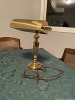 Front view of brass desk lamp on table