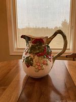 Front view of Fitz and Floyd grapevine pitcher on table