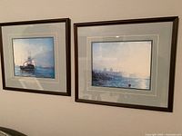 Both framed prints hanging on wall