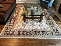 Full view of rug beneath glass coffee table showing entire design and scale