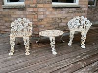 Two wrought iron chairs and round table