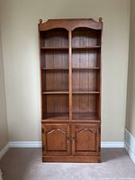 Front view of tall Roxton maple bookcase showing shelves and cupboard