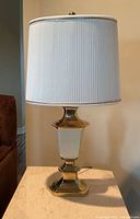 Front view of table lamp showing base, body, and shade