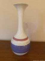 Full view of tall ceramic vase showing shape and color bands