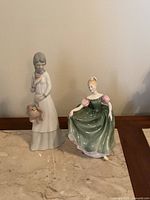 Both figurines side by side showing full forms and surface condition