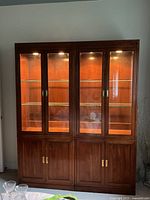 Front view of both display cabinets showing glass doors and lit interiors