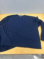 Front view of one navy long-sleeve shirt laid flat