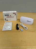 Entire kit laid out: box, lamp, cable, adhesive bottle, ring, instructions