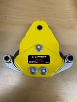 Front view of Lippert Equa-Flex equalizer showing yellow body, bolts, label