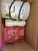 Box contents showing two Frabill bait buckets, fire blanket and roll of plastic bags