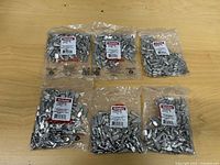 Six sealed bags of Richelieu CP2289180 shelf pins on table