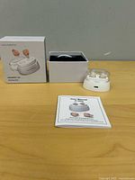 Full lot showing box, charging dock with hearing aids and manual