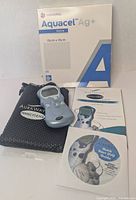 All items laid out: TENS unit, pouch, DVD, manual, electrode pads, Aquacel dressings