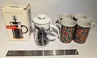 Lot overview showing French press, four mugs, box, ruler for scale