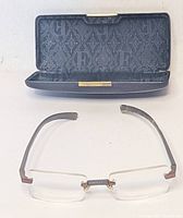 Eyeglasses front view with open hard case showing interior logo pattern