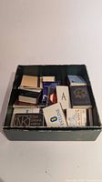 Box holding assorted matchbooks and matchboxes