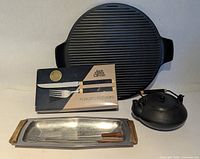 Group shot of grill pan, boxed flatware, aluminium tray with skewers and iron teapot