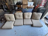 All four beige seat/back cushions aligned on floor