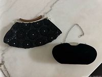 Front view of both purses closed showing beadwork and velvet surfaces