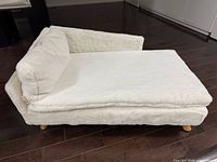 Front corner view of white plush pet sofa bed showing overall design and cushion