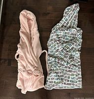 Both bathrobes laid flat on floor showing color, pattern, hoods and belts