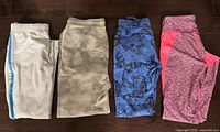 Four folded pairs of kids sweatpants in various colours and patterns