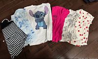 Six girls T-shirts laid on floor showing fronts and patterns