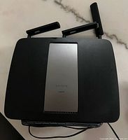 Top view of Linksys EA9200 router showing three antennas and silver center panel